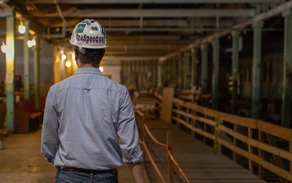 Man with hard helmet walking away from camera